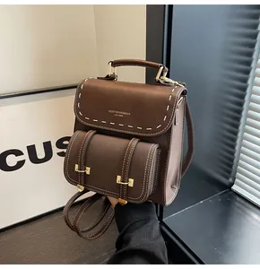 Vintage brown leather backpack with white stitching and gold hardware detail