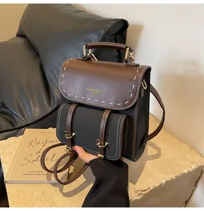 Detail of vintage faux leather backpack with white contrast stitching and gold logo