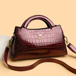 Elegant wine red crocodile embossed patent leather tote bag with gold-tone hardware detail.