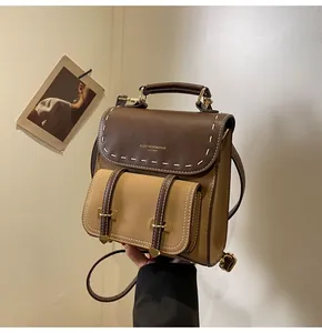 Close-up view of a vintage brown leather backpack with elegant hand-held detail.