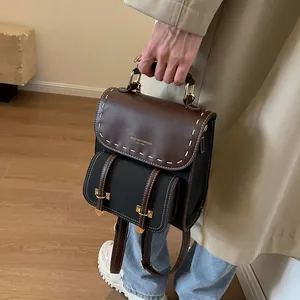 Vintage leather backpack with top handle and decorative stitching in brown and black