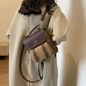 Elegant vintage brown and tan patchwork backpack with stylish contrast stitching.