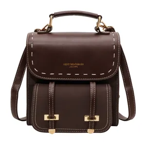 Classic vintage dark brown leather backpack featuring white stitching and elegant gold hardware