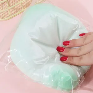 Soft mint green slow rebound squishy stress relief toy being squeezed in a plastic bag