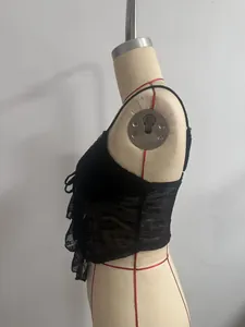Seitenansicht eines schwarzen floralen Spitzen-Camisole-Tops mit Rüschensaum auf Schneiderpuppe