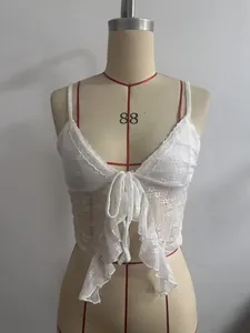 Detaillierte Ansicht eines weißen Spitzen-Trägertops mit Frontschleife und Rüschen