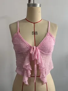 Detail eines rosa Spitzen-Camisole-Tops mit Blumenstickerei und Bindeschleife