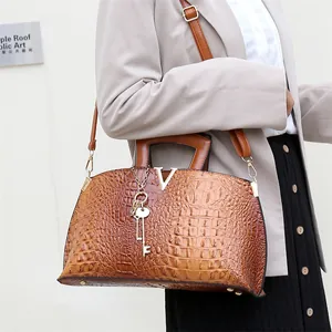 Fashionable brown crocodile embossed handbag with V-logo detail and crossbody strap