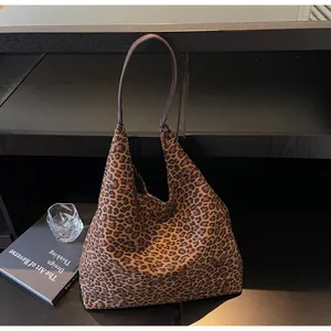 Vista dettagliata di una grande borsa tote scamosciata con stampa leopardata su scaffale
