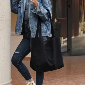 Minimalist large black canvas tote bag for college students in street fashion style