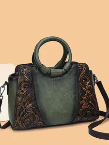 Vintage leather handbag with elegant green floral embossing and circular top handle.