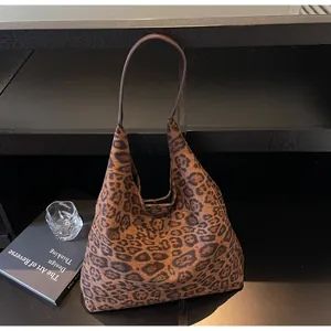 Elegante borsa tote in pelle scamosciata maculata su uno scaffale nero moderno