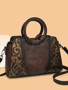 Vintage embossed leather crossbody bag with floral pattern and circular handles