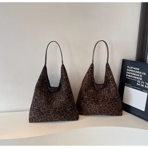 Grandi borse tote in pelle scamosciata maculata in un ambiente da studio minimalista