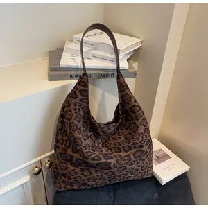 Grande borsa tote in pelle scamosciata leopardata in un ambiente interno minimalista