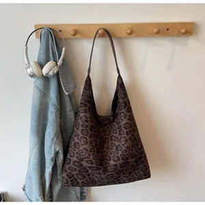 Elegante borsa tote in pelle scamosciata maculata appesa in scena lifestyle