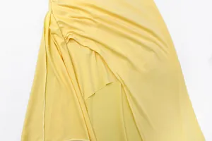 Close-up detail of yellow sexy side slit dress with elegant pleats and draping