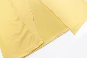 Detailed view of the side slit and high-quality hemline stitching on a yellow bodycon dress