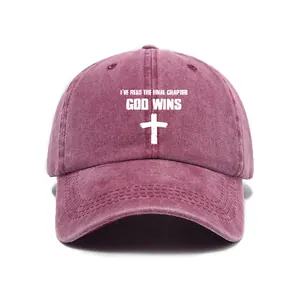 Close-up view of burgundy washed baseball cap with white cross and God Wins text
