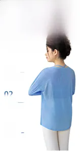 Back view of a light blue bamboo yarn long-sleeved yoga top with side slits.