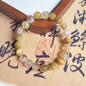 Macro detail of natural golden tiger eye and rutilated quartz beaded bracelet jewelry
