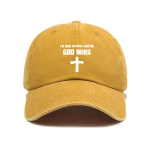 Close-up of mustard yellow washed denim baseball cap featuring God Wins cross print