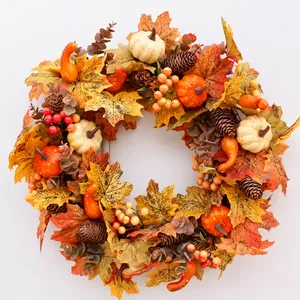 Détail d'une couronne de récolte d'automne avec feuilles d'érable, citrouilles et baies