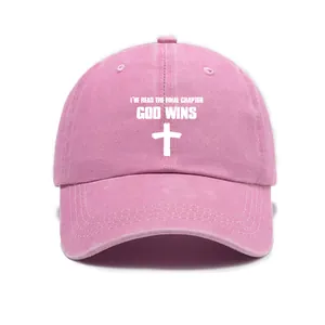 Detailed view of pink washed denim cap with cross print and God Wins text