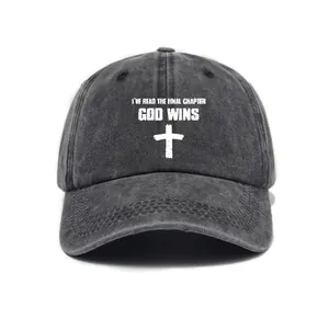 Close-up detail of the washed denim baseball cap featuring God Wins and cross print