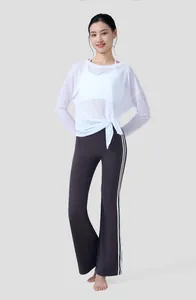 Full body shot of a model wearing a white breathable slub yarn yoga long sleeve top