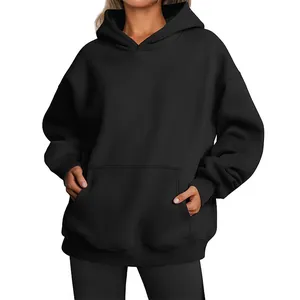 Detail shot of black oversized hoodie featuring spacious kangaroo pocket and ribbed cuffs.