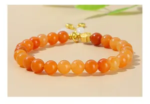 Dettaglio di bracciale in perle di avventurina rossa e giada bianca con ciondolo