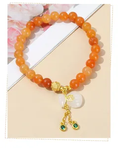 Dettaglio del bracciale con perle di avventurina rossa e ciondolo in giada bianca