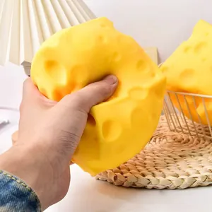 Close-up of hand squeezing a large realistic yellow cheese squishy toy