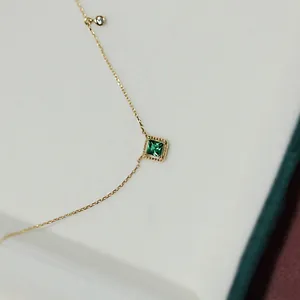 Detailed close-up of a square emerald pendant on a 14K gold plated S925 silver necklace