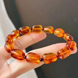 Detailed macro shot of natural amber honey wax beaded bracelet in warm orange tones