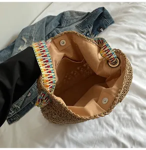 Detailed interior view of a straw tote bag with colorful wide shoulder strap