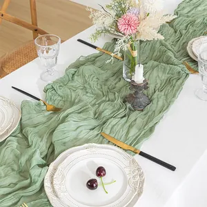 Sage green cheesecloth table runner with rustic crinkle texture for wedding decor.