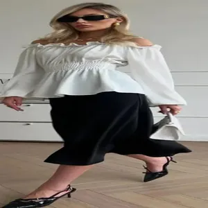 Full view of white off-shoulder long sleeve blouse with smocked waist and ruffles