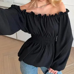 Detailed macro view of black off-shoulder blouse with smocked waist and ruffles