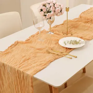 Chemin de table élégant en gaze champagne avec texture plissée rustique pour décoration mariage.