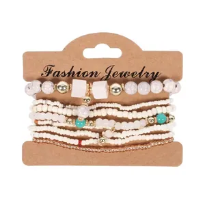 Vista dettagliata di un set di 8 braccialetti elastici con perline boho su carta.