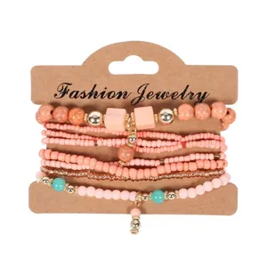 Primo piano di un set di 8 braccialetti elastici bohémien con perline color corallo e turchese