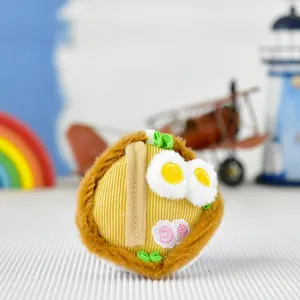 Gros plan d'un mignon pendentif en peluche ramen avec détails d'œuf et de gâteau de poisson.