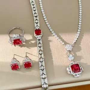 Dettaglio ravvicinato di un set di gioielli vintage con pietre rosse e zirconi brillanti.