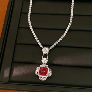 Dettaglio ravvicinato di una collana con ciondolo quadrato rosso in stile palazzo.