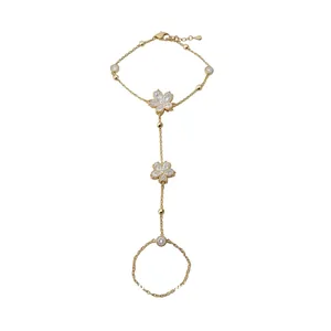 Elegant 14k gold plated hand chain featuring sparkling cubic zirconia flower pendants