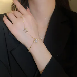 Detailed view of 14k gold plated flower bracelet with zircon stones on a model hand
