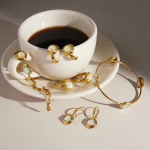 Elegante set di gioielli in oro e acciaio al titanio con inserti in resina iridescente.