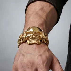 Close-up of a bold gold-colored skull bracelet in a punk motorcycle style worn on a wrist.